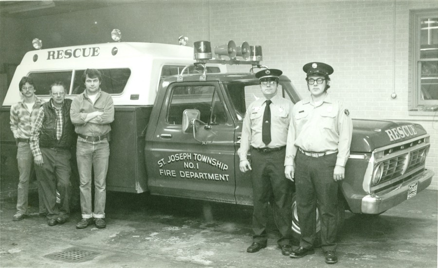 Members standing beside the 1970s Rescue 25 at the station